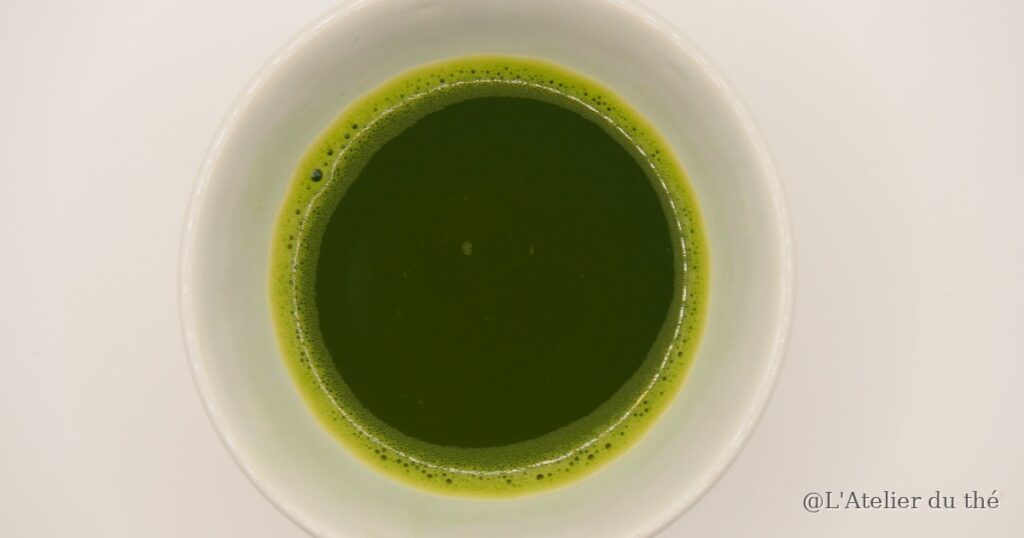 Couleur verte profonde de la liqueur d'un matcha préparé avec l'eau du robinet filtrée, dans un bol blanc