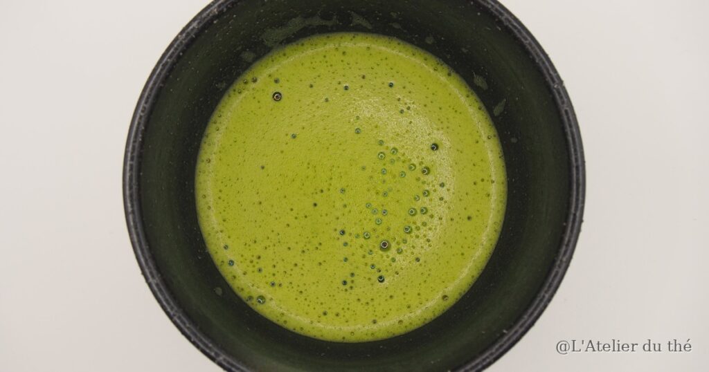 Mousse fine de matcha préparé avec l'eau du robinet filtrée, vue du dessus dans un chawan noir